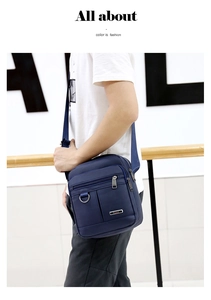 Detail of navy blue Oxford fabric messenger bag with adjustable strap and metal D-ring