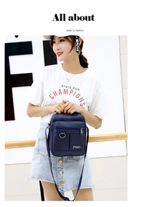 Detail of dark blue waterproof nylon shoulder bag with zipper pockets and D-ring