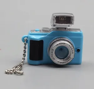 Close-up of sky blue miniature dollhouse toy camera with silver bead chain and flash detail