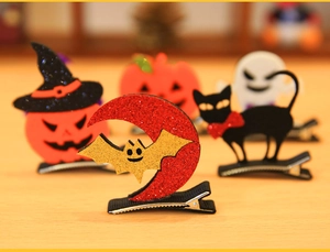 Detail of Halloween hair clips with glitter pumpkin, cat, and ghost on metal duckbill clips