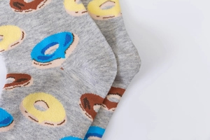 Macro shot of gray cotton socks featuring blue and yellow donut patterns on the heel