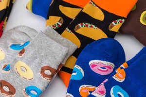Close-up of colorful cotton crew socks featuring taco and donut food patterns