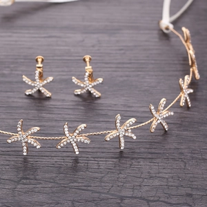 Detail of gold starfish bridal headpiece and clip-on earrings with white rhinestones