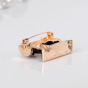 Retro gold sewing machine brooch with black enamel inlay and secure pin clasp design