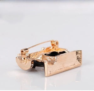 Macro shot of gold-plated sewing machine brooch with safety pin clasp and rhinestones