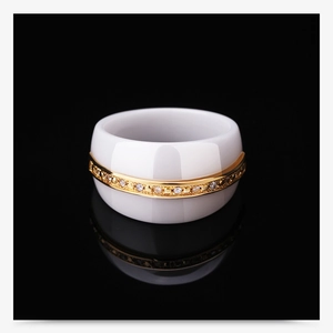Detailed close-up of 14mm white ceramic ring with gold-plated rhinestone inlay