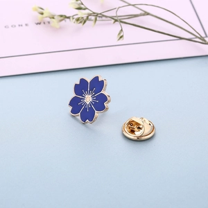 Macro detail of dark blue cherry blossom enamel brooch with gold plating and butterfly clutch
