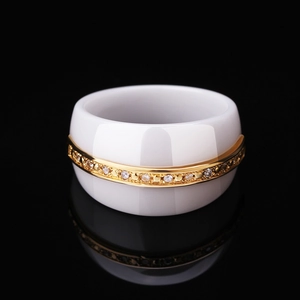 Minimalist white ceramic ring with gold plating and paved rhinestones on black background