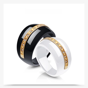 Detail of 14mm black and white ceramic rings with gold diamond-set center band