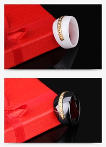 Detail of wide black and white ceramic rings with gold band and sparkling crystal inlay