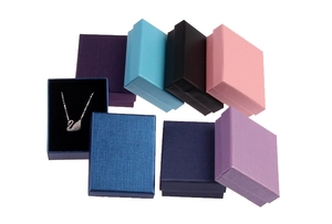 Close-up of colorful kraft paper jewelry gift boxes with swan necklace display