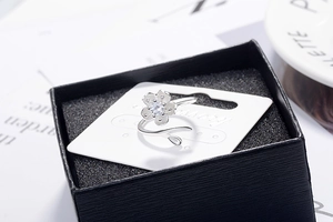 Macro detail of silver cherry blossom ring with sparkling cubic zirconia on floral petals