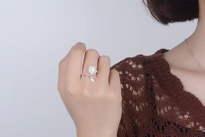 Detail of silver cherry blossom ring with flower design worn on model's hand