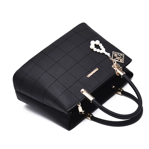 Elegant black quilted leather tote bag with pearl pendant and gold hardware details