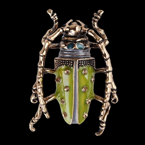 Vintage gold and green enamel beetle brooch with sparkling rhinestones on black background