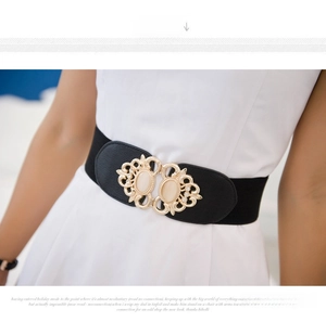 Detail of elastic waist belt with gold hollow carved buckle and white cat-eye stone