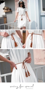 Detailed close-up of brown braided PU leather waist belt with elegant tassel fringe