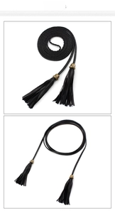 Detail of black woven PU leather thin belt with vintage bronze metal and tassel fringes