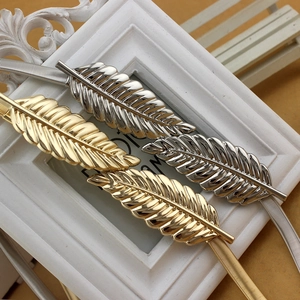 Elastic gold and silver leaf buckle waist belts displayed on an elegant frame