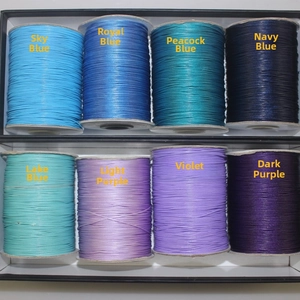 Macro detail of eight rolls of colorful waxed cord for DIY jewelry braiding