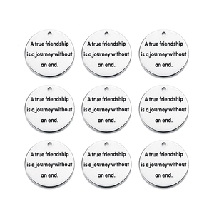 Macro shot of 9 round stainless steel tags with engraved friendship quote on white background