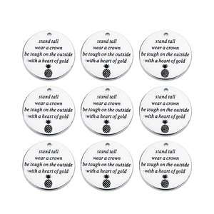 Detailed view of nine engraved stainless steel discs for DIY jewelry necklace making
