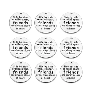 Macro view of 5 vintage stainless steel round charms with engraved friendship quote