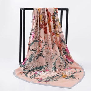 Detailed drape of floral satin square scarf in peach with vibrant flower patterns