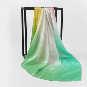 Detail of a gradient satin silk scarf draped over a black frame with soft folds