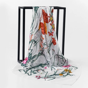 Detailed close-up showing the smooth silk satin texture and floral print of the scarf