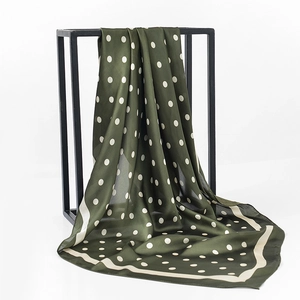 Detailed view of dark green polka dot satin scarf hanging with silk-like texture