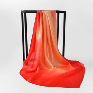 Detail of silk satin scarf with red orange gradient draped on a black metal frame