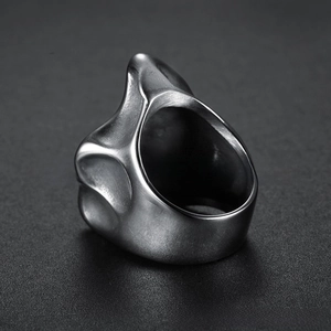Macro shot of matte brushed stainless steel skull ring with wide band and textured finish