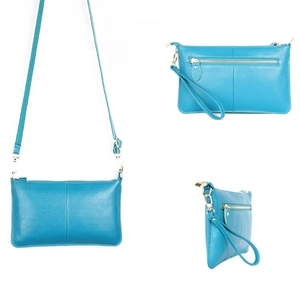 Macro view of sea blue pebble leather bag with gold zippers and detachable straps