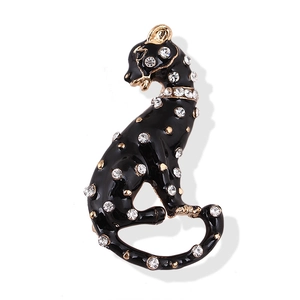 Elegant black enamel panther brooch with sparkling crystals and gold accents on white base