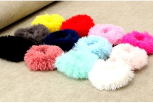 Detailed overhead view of plush faux rabbit fur scrunchies in diverse vibrant candy colors