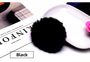 Detail of soft black faux rabbit fur scrunchie on a decorative white porcelain plate