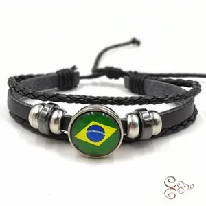 Detail of multi-layer braided leather bracelet featuring a glass Brazil flag charm