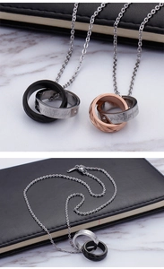Macro shot of interlocking double ring pendant necklaces with engraved 'you till the end' text