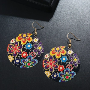 Detailed view of round earrings with vibrant floral patterns and gold-tone hooks
