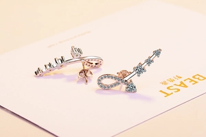 Macro detail of silver infinity earrings with zircon inlays on display card
