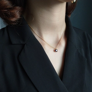 Close-up of a 925 silver gold-plated necklace with a 5mm round blue gemstone pendant