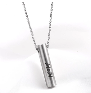Detailed view of silver cylindrical urn necklace engraved with MOM in brushed metal finish