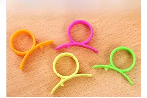 Detailed view of colorful plastic citrus peelers in four bright colors on a wooden board