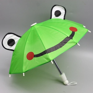Close-up of green frog-themed doll umbrella with 3D eyes and white plastic handle