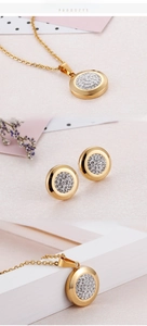 Detailed view of gold stainless steel necklace and stud earrings set with pavé crystals