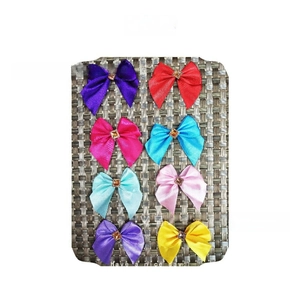 Colorful satin hair bows set with central crystal rhinestones on a textured display