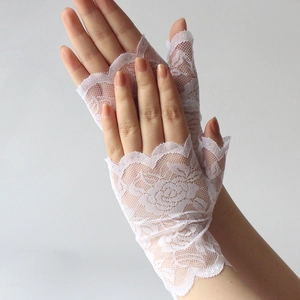 Detailed view of white floral lace gloves with fingerless design and elegant rose patterns
