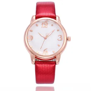 Close-up of red honeycomb embossed leather strap and floral dial on rose gold watch