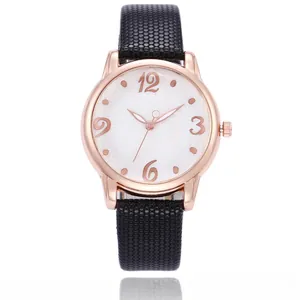 Close-up of rose gold watch case with daisy print dial and black textured leather strap
